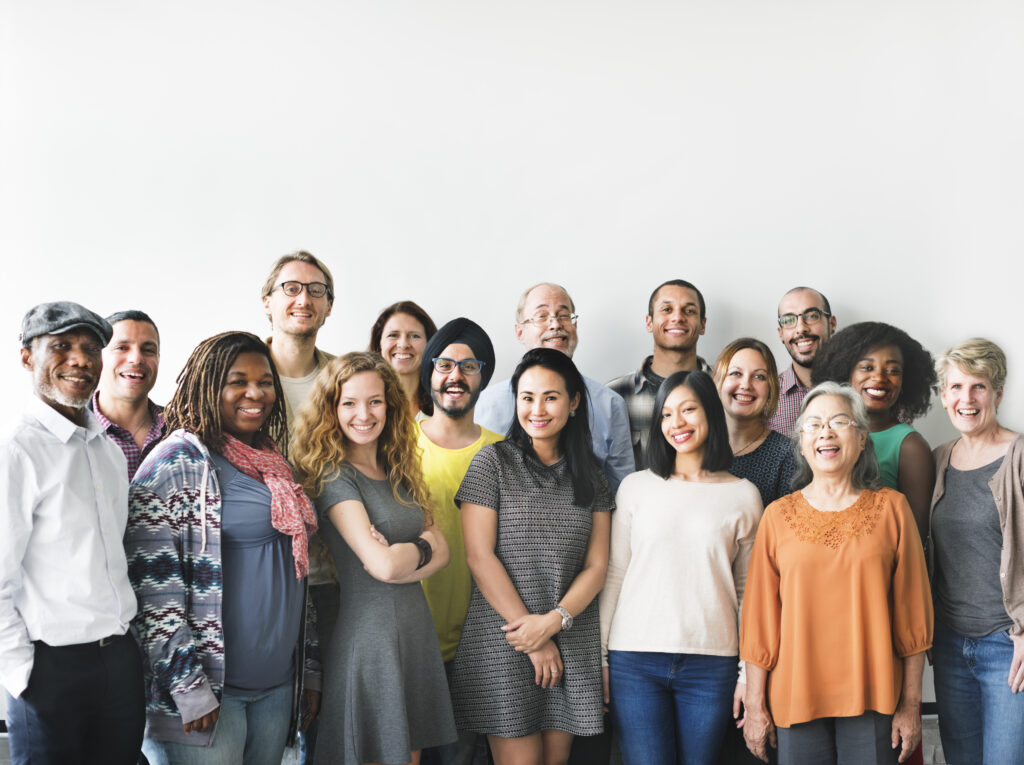 Diverse group of adults of different ages smiling together, representing preventive health and early detection across life stages.