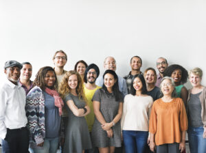 Diverse group of adults of different ages smiling together, representing preventive health and early detection across life stages.